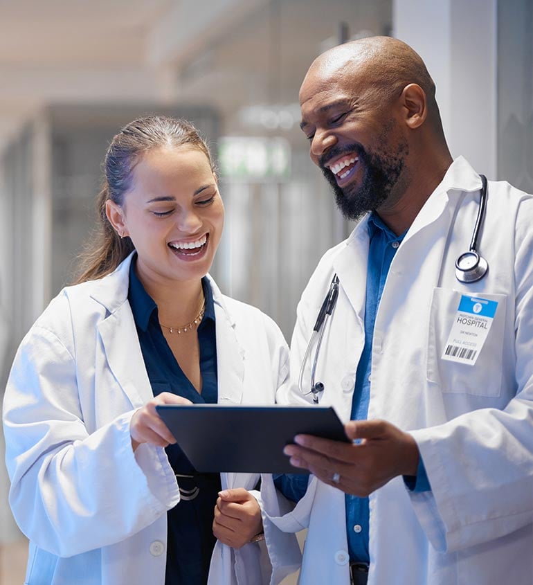 doctors smiling looking at a tablet